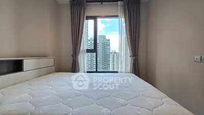 Modern bedroom with large window offering stunning city views, featuring a comfortable bed and elegant curtains.