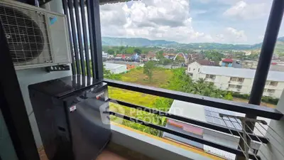 Scenic balcony view with air conditioning unit and washing machine overlooking lush landscape.
