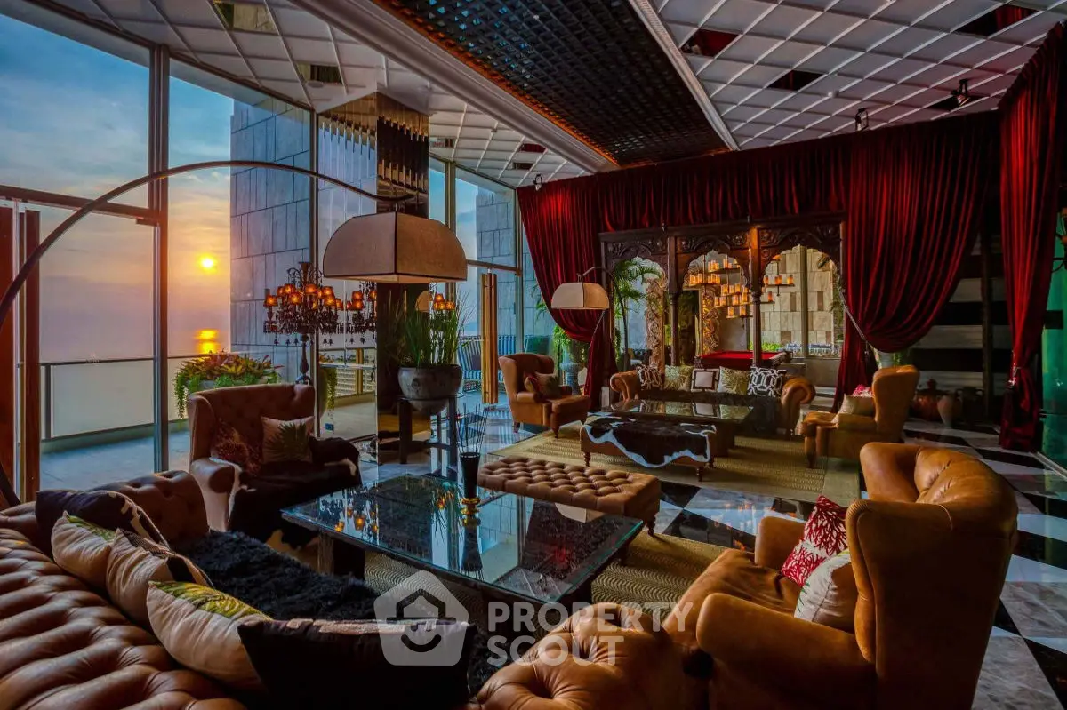 Luxurious living room with sunset view, elegant decor, and plush seating in high-rise apartment.