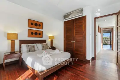 Luxurious bedroom with wooden flooring and elegant decor in a modern apartment.