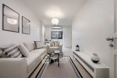 Modern living room with stylish decor and neutral tones, featuring a cozy sofa and elegant lighting.