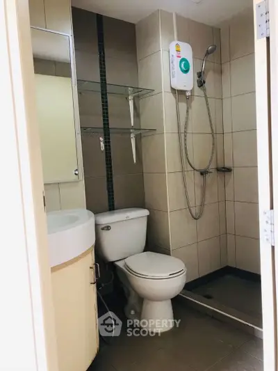 Compact bathroom with shower, toilet, and sink in modern apartment.