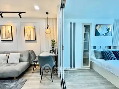 Modern open-plan living room and bedroom with stylish decor and cozy furnishings.