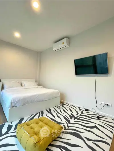 Modern bedroom with stylish decor and wall-mounted TV