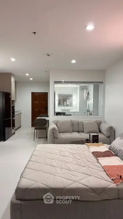 Modern living room with cozy sofa and open kitchen layout in stylish apartment.