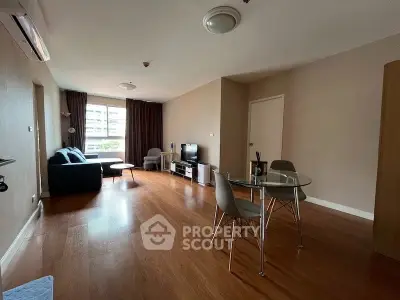 Spacious living room with modern furniture and large window view.