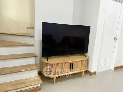 Modern living room corner with stylish TV stand and staircase