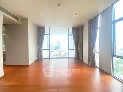 Spacious high-rise apartment with floor-to-ceiling windows and stunning city view.