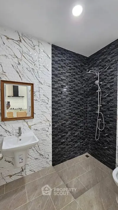 Modern bathroom with stylish black and white tile design and sleek fixtures.