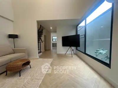 Spacious modern living room with large window and stylish decor