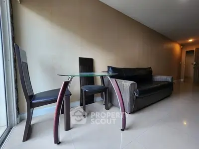 Modern living room with sleek glass table and stylish black leather sofa