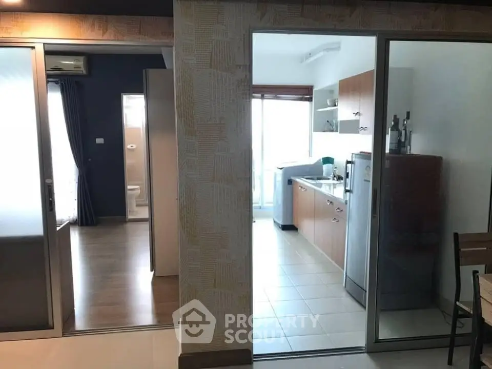 Modern apartment interior with kitchen and living area, featuring sleek design and ample natural light.