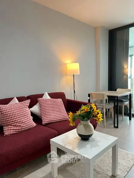 Modern living room with red sofa, stylish decor, and cozy lighting