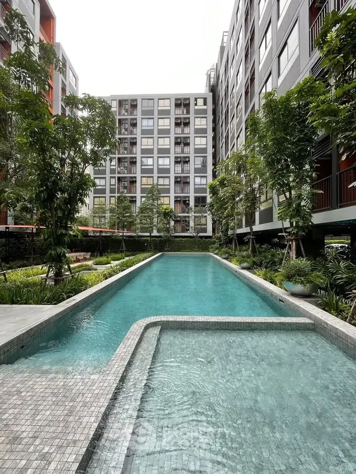 Luxurious apartment complex with stunning pool and lush greenery