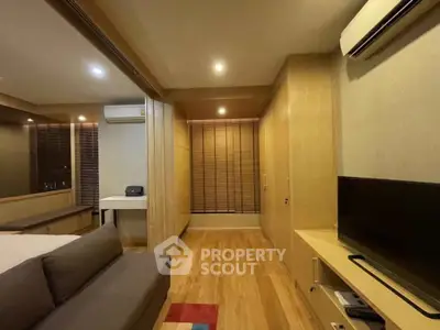 Modern living room with wooden flooring, air conditioning, and cozy lighting