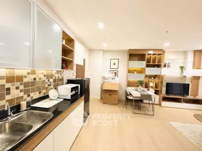 Modern open-layout kitchen and living room with stylish decor and ample storage space.