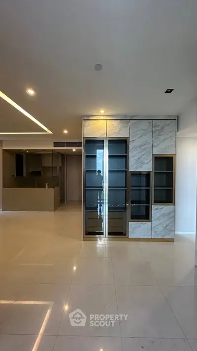 Spacious modern living room with elegant built-in storage and open kitchen layout.