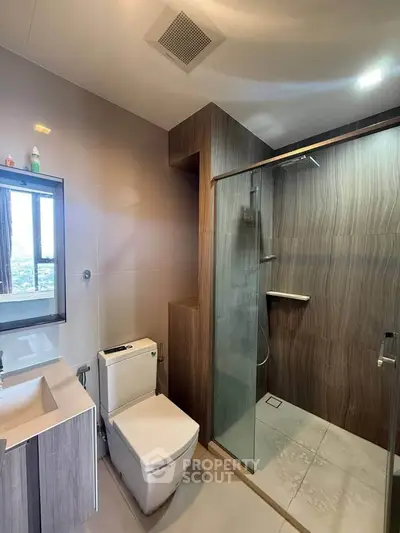 Modern bathroom with glass shower and sleek fixtures in a contemporary apartment.