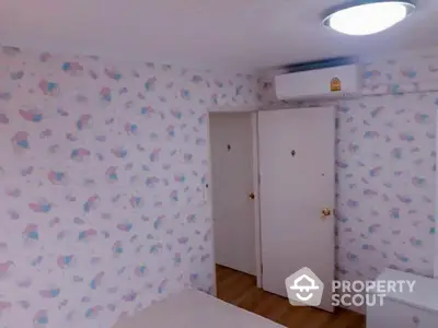 Cozy bedroom with whimsical wallpaper design, built-in closet, and modern air conditioning unit, perfect for comfortable living.