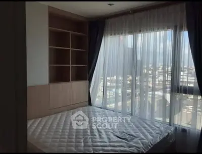 Spacious bedroom with large windows offering stunning city views.