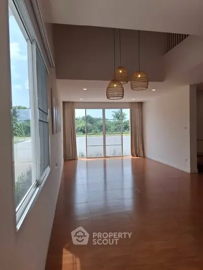 Spacious living room with large windows and elegant pendant lighting
