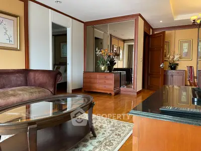 Elegant living room with wooden furniture and glass coffee table in a luxurious apartment.