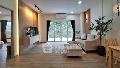 Spacious modern living room with elegant decor and large windows offering scenic views.