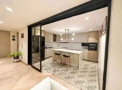 Modern open-layout kitchen with island and stylish lighting in a contemporary apartment.