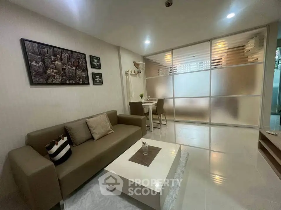Modern living room with stylish decor and frosted glass partition in a cozy apartment.