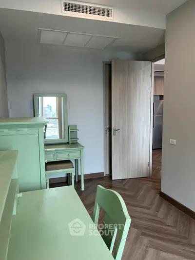 Charming bedroom with mint green furniture and city view, perfect for a cozy urban retreat.