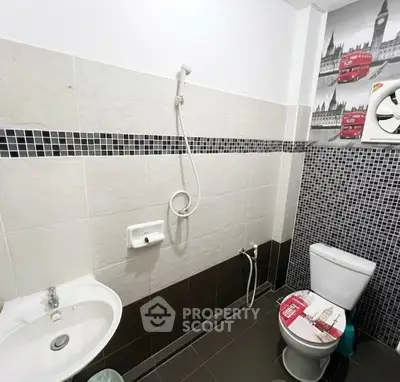 Modern bathroom with shower and toilet featuring stylish black and white tiles.
