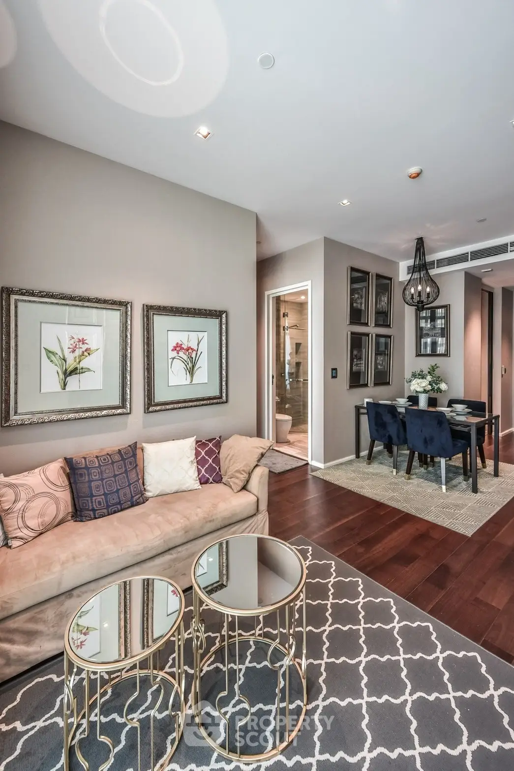 Luxurious living room with elegant decor and dining area, featuring plush sofa and stylish lighting.