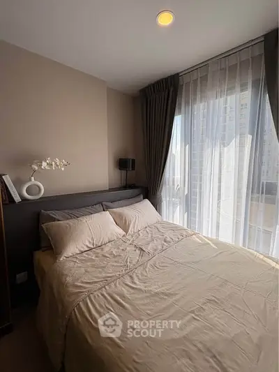 Cozy bedroom with large window and elegant curtains in modern apartment