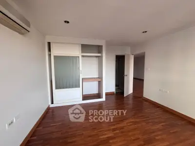 Spacious bedroom with wooden flooring and built-in wardrobe