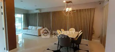 Spacious living room with elegant dining area and modern lighting, perfect for entertaining guests.