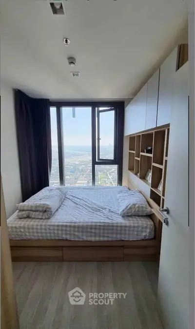 Modern bedroom with panoramic city view and stylish built-in storage solutions.