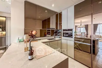 Luxurious modern kitchen with sleek cabinetry and open layout leading to elegant living room.
