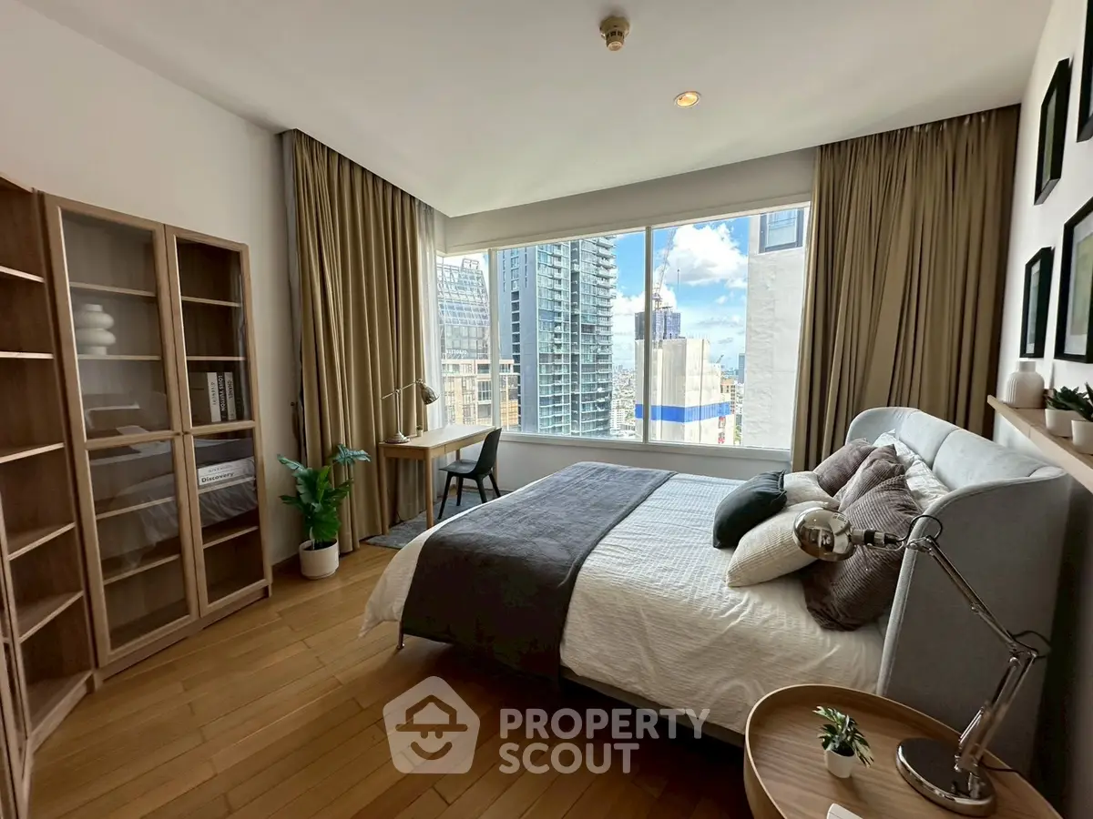 Spacious bedroom with city view, modern furnishings, and ample natural light.