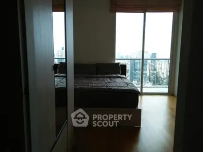 Modern bedroom with city view and large window in high-rise apartment
