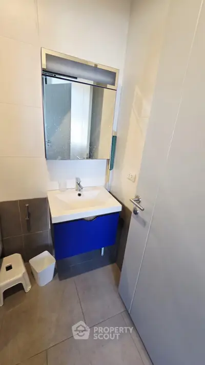 Modern bathroom with sleek blue vanity and large mirror