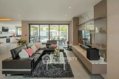 Luxurious modern living room with sleek black leather sofa and open kitchen layout