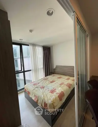 Modern bedroom with large windows and stylish decor in a high-rise apartment.