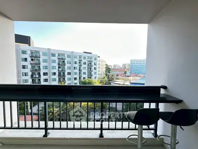 Modern balcony with city view and stylish seating, perfect for relaxation.