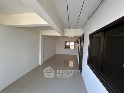 Spacious empty room with large windows and tiled flooring, ideal for customization.