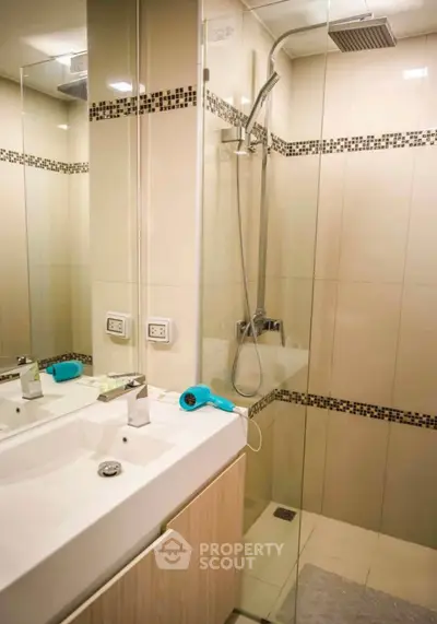 Modern bathroom with glass shower and stylish vanity in contemporary apartment.