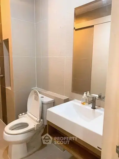 Modern bathroom with sleek fixtures and neutral tiles, perfect for a contemporary home.