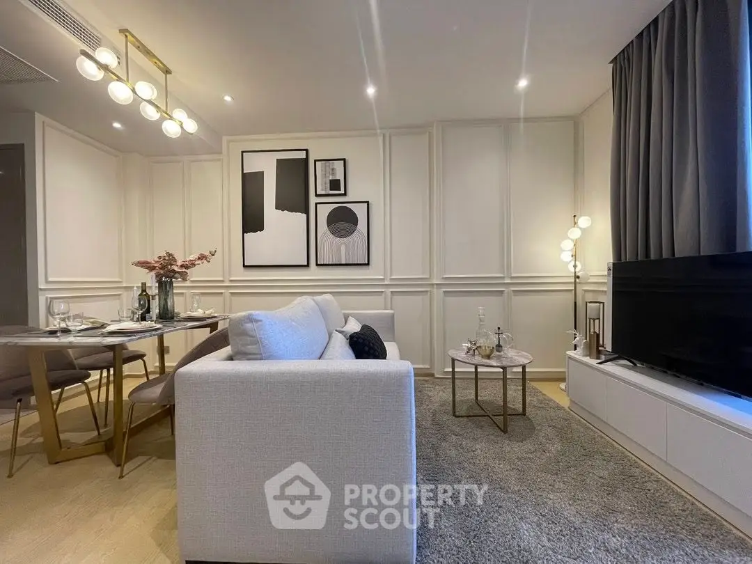 Modern living room with elegant decor and dining area, featuring stylish lighting and contemporary art.