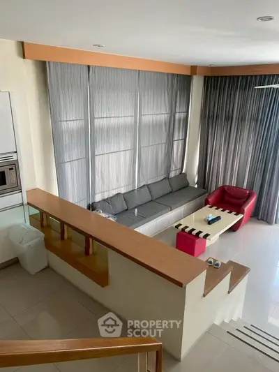 Modern living room with stylish furniture and large windows, perfect for relaxation and entertainment.