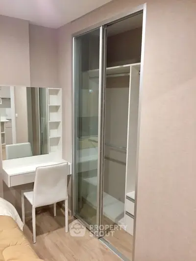 Modern bedroom with sliding closet and vanity desk in stylish apartment