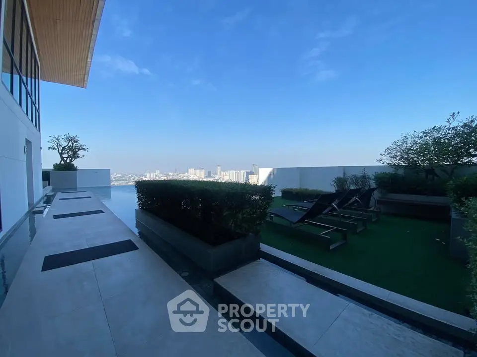 Luxurious rooftop terrace with stunning city view and modern lounge chairs.